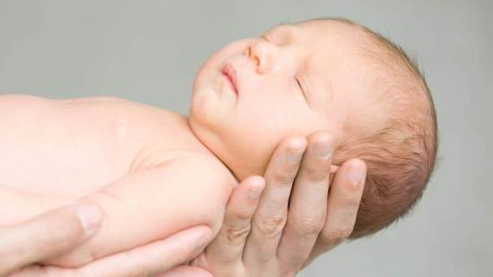 Portrait of a sleeping newborn hold at hands