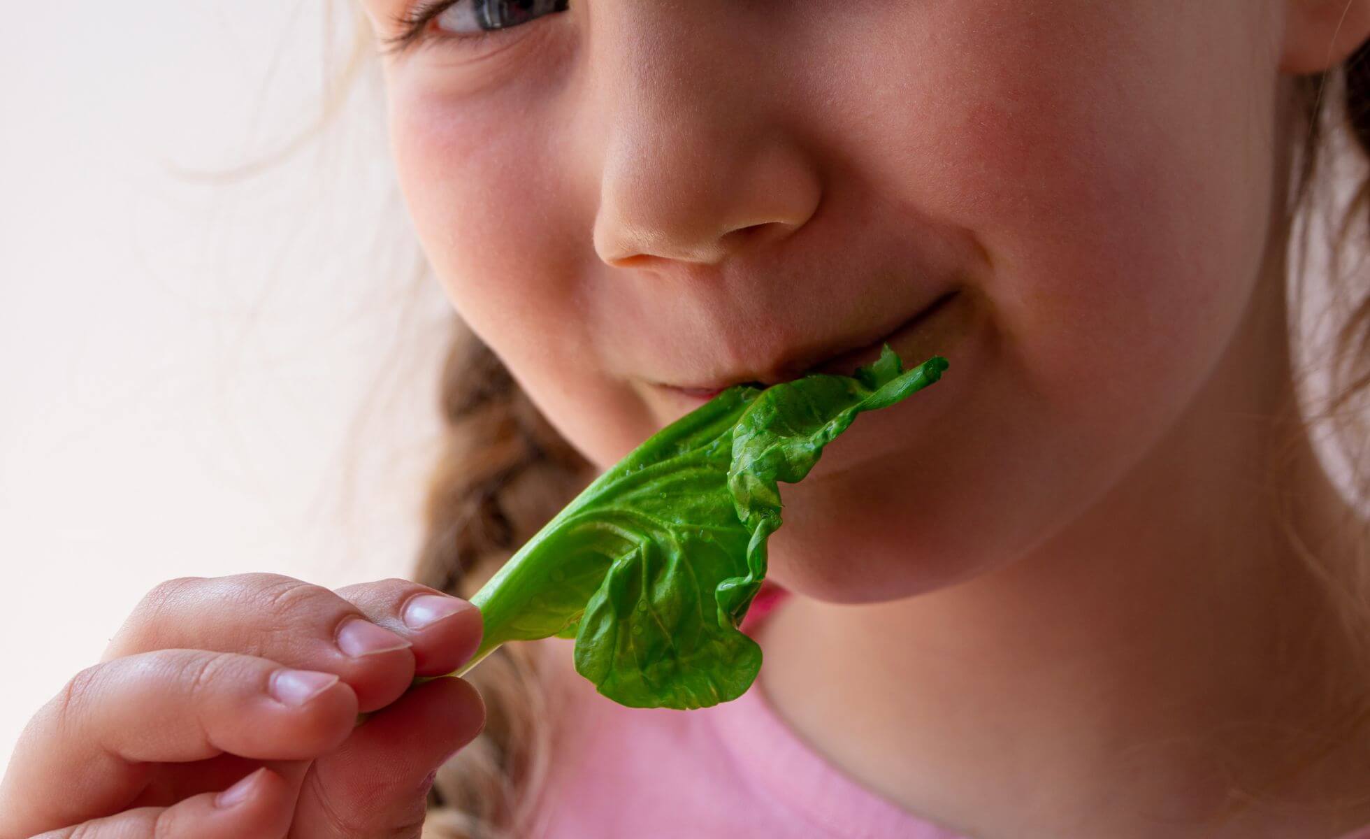 Niña comiendo espinaca