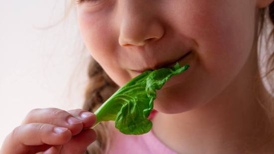 Niña comiendo espinaca